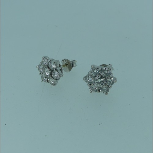 206 - A pair of diamond flowerhead cluster Earrings, the central circular diamond approx 0.17ct, claw set ... 