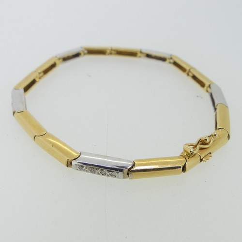 184 - An 18ct two colour gold flexible line Bracelet, formed of hinged rectangular yellow and white gold l... 