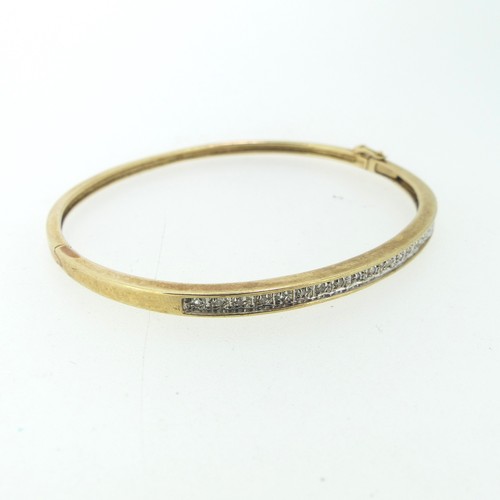 185 - A narrow 9ct gold hinged Bangle, the front set with nineteen small diamond points, 5.5cmx4.8cm inter... 