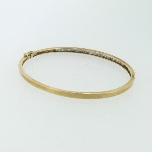 185 - A narrow 9ct gold hinged Bangle, the front set with nineteen small diamond points, 5.5cmx4.8cm inter... 