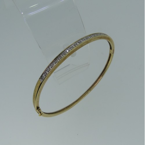 185 - A narrow 9ct gold hinged Bangle, the front set with nineteen small diamond points, 5.5cmx4.8cm inter... 