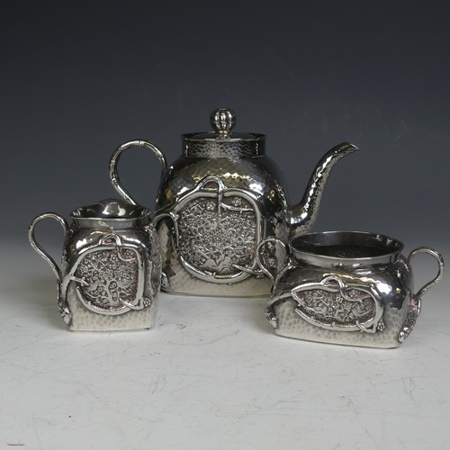 An early 20thC Chinese export silver three piece Tea Set, of cube form with rounded shoulders, hammered body with applied and embossed naturalistically modelled foliate decoration, twin bamboo scroll handles, the teapot with lift off cover and flower bud knop finial, with faux seal mark to body, character marks to base, teapot 14cm high, approx total weight 24.1ozt, milk jug with some dents and knocks (3)