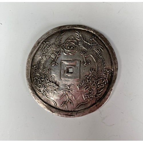 352 - A 19thC Asian silver Coin, one side with four character marks, the other with two stylised dragons, ... 