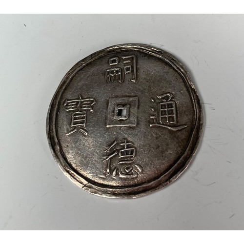 352 - A 19thC Asian silver Coin, one side with four character marks, the other with two stylised dragons, ... 