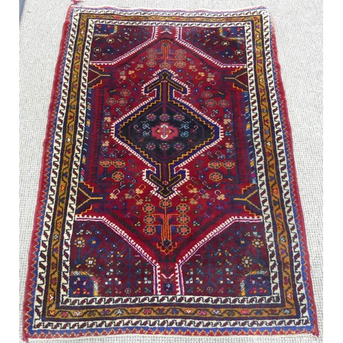 604 - Tribal Rugs; a Persian Qashqai Rug, red ground, thick wool pile on cotton base, worn along one edge,... 