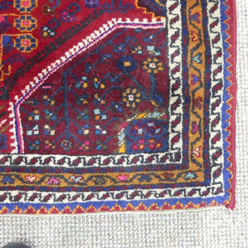 604 - Tribal Rugs; a Persian Qashqai Rug, red ground, thick wool pile on cotton base, worn along one edge,... 