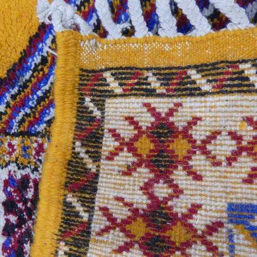 611 - Tribal Rugs; a vintage yellow ground Rug, possibly Moroccan, with two central medallions and wide br... 