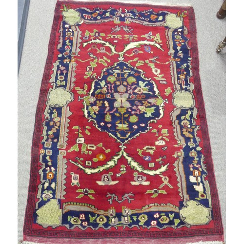 612 - Tribal Rugs; a Persian Rug, red ground with bold patterns, wool pile on wool base, pile and fringes ... 