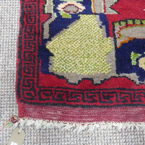 612 - Tribal Rugs; a Persian Rug, red ground with bold patterns, wool pile on wool base, pile and fringes ... 