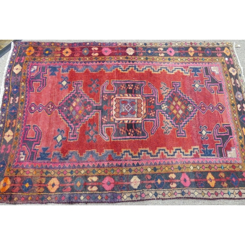 614 - Tribal Rugs; an old Caucasian Rug, red ground with three central medallions within a geometric patte... 