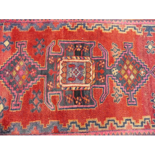 614 - Tribal Rugs; an old Caucasian Rug, red ground with three central medallions within a geometric patte... 