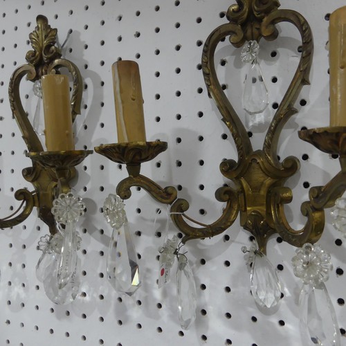 578 - A pair of early 20thC gilt brass two branch Wall Sconces, adorned with crystal glass drops, H34cm x ... 