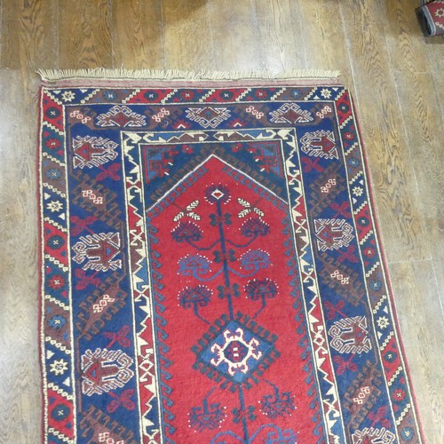 615 - Tribal Rugs; a Turkish Rug, blue and red ground with tree of life patterns set within a geometric pa... 