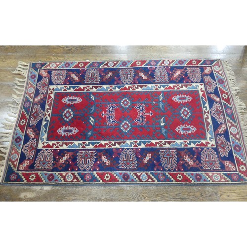 616 - Tribal Rugs; a Turkish Rug, blue and red ground with all over geometric pattern set within a wide bo... 