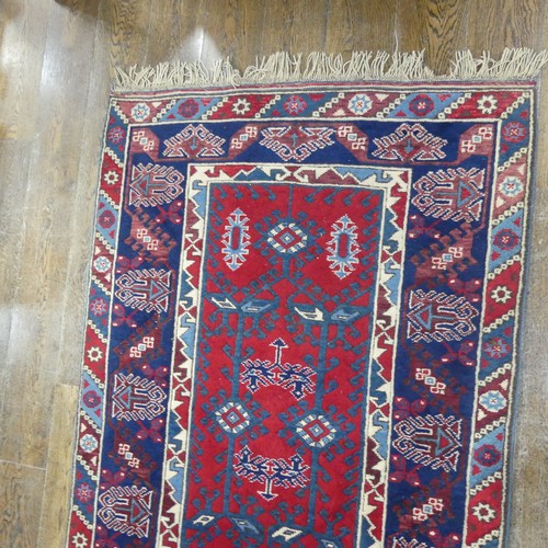 616 - Tribal Rugs; a Turkish Rug, blue and red ground with all over geometric pattern set within a wide bo... 