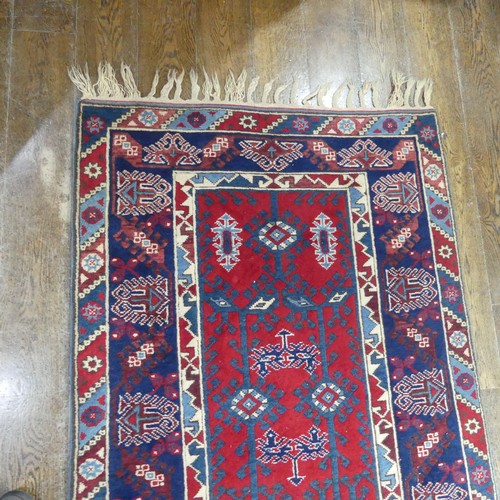 616 - Tribal Rugs; a Turkish Rug, blue and red ground with all over geometric pattern set within a wide bo... 