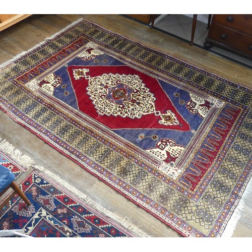 617 - Tribal Rugs; an old Turkish Yahyali Rug, blue and red ground with cream central medallion, within a ... 