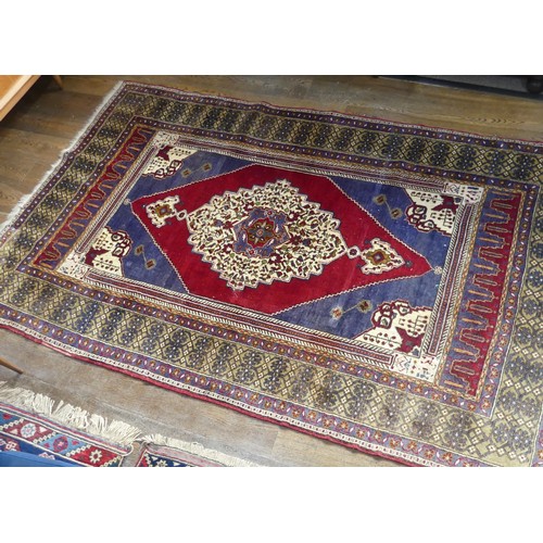 617 - Tribal Rugs; an old Turkish Yahyali Rug, blue and red ground with cream central medallion, within a ... 