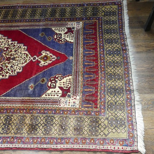 617 - Tribal Rugs; an old Turkish Yahyali Rug, blue and red ground with cream central medallion, within a ... 