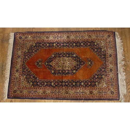 613 - Tribal Rugs; an old Persian finely knotted 100% silk rug, burnt orange ground with dark blue border ... 