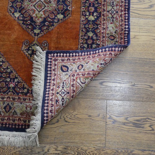 613 - Tribal Rugs; an old Persian finely knotted 100% silk rug, burnt orange ground with dark blue border ... 