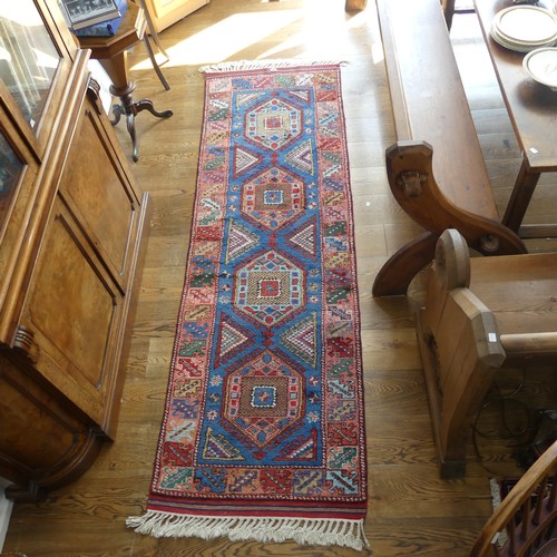 609 - Tribal Rugs; a blue ground Caucasian Runner, the whole with typical geometric patterns in bright col... 