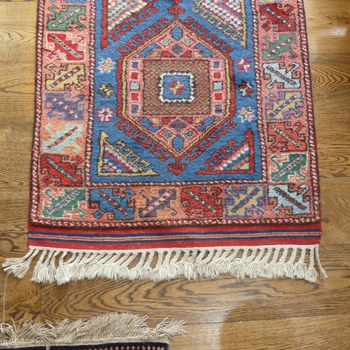 609 - Tribal Rugs; a blue ground Caucasian Runner, the whole with typical geometric patterns in bright col... 