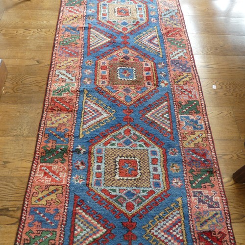 609 - Tribal Rugs; a blue ground Caucasian Runner, the whole with typical geometric patterns in bright col... 