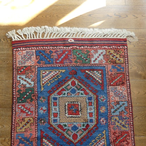 609 - Tribal Rugs; a blue ground Caucasian Runner, the whole with typical geometric patterns in bright col... 