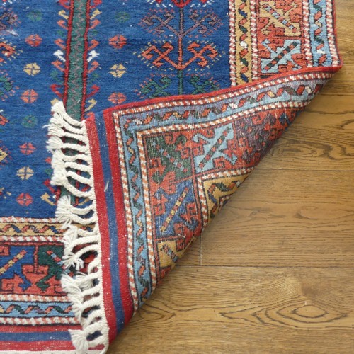 610 - Tribal Rugs; a blue ground Caucasian Rug, with tree of life designs and geometric patterned borders ... 