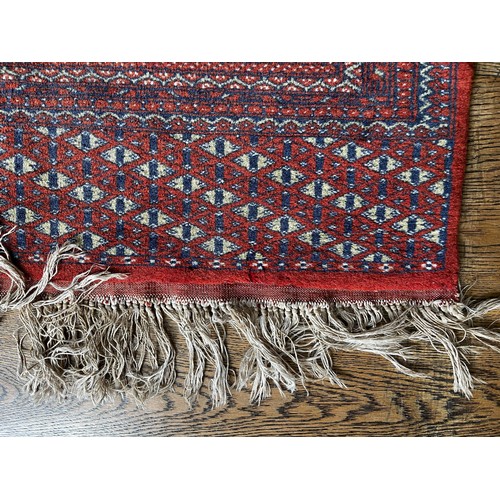 517 - Tribal Rugs; a fine hand-knotted old Turkomen Bokhara rug, short wool pile on silk base, the salmon ... 