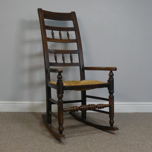 389 - An Antique elm Rocking Chair, with rush seat, W 50.5 cm x H 102 cm x D 67 cm.