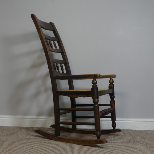 389 - An Antique elm Rocking Chair, with rush seat, W 50.5 cm x H 102 cm x D 67 cm.