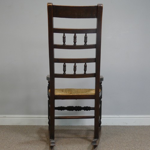 389 - An Antique elm Rocking Chair, with rush seat, W 50.5 cm x H 102 cm x D 67 cm.