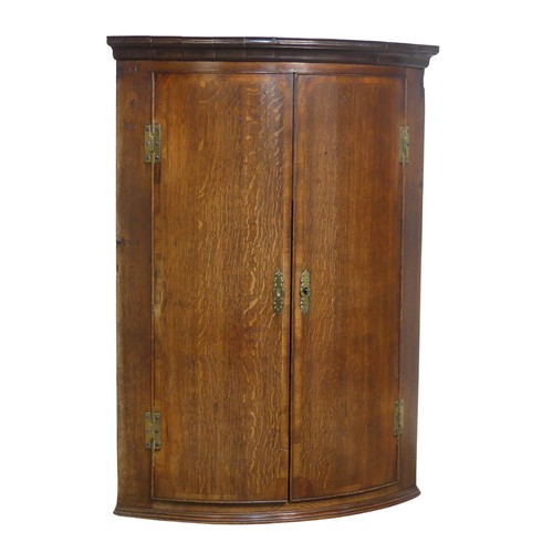 390 - A Georgian oak bow-front wall Corner Cupboard, W 70 cm x H 98 cm x D 47 cm.