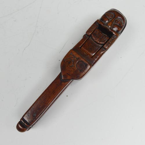 392 - An Early Folk treen Nut Cracker, possibly 17th century, featuring a totem style head in naïve form, ... 