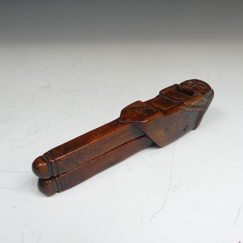 392 - An Early Folk treen Nut Cracker, possibly 17th century, featuring a totem style head in naïve form, ... 