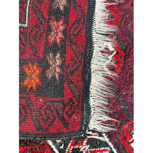 518 - Tribal Rugs; an Afghan red-ground rug, 100% wool, 153cm x 89cm.