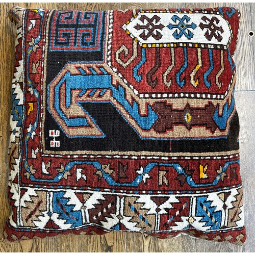 519 - Tribal Rugs; a large Baluchi tent bag/camel bag, 146cm x 80cm, together with a large rug-backed cush... 