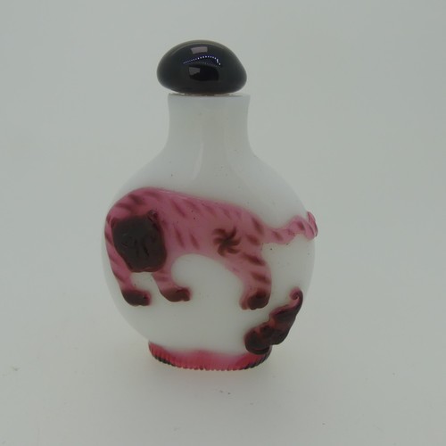 98 - A Chinese Peking glass Snuff Bottle, of white ground with overlayed pink depictions of a Tiger, Bat ... 