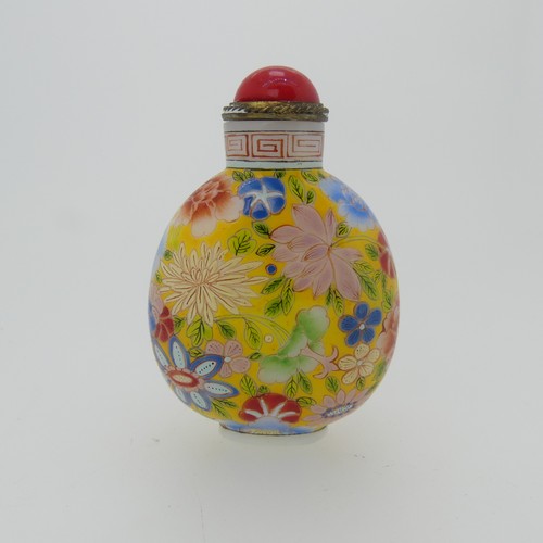 100 - A Chinese glass Snuff Bottle, of yellow ground painted with floral enamels, red stone stopper, three... 