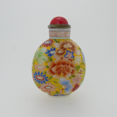 100 - A Chinese glass Snuff Bottle, of yellow ground painted with floral enamels, red stone stopper, three... 