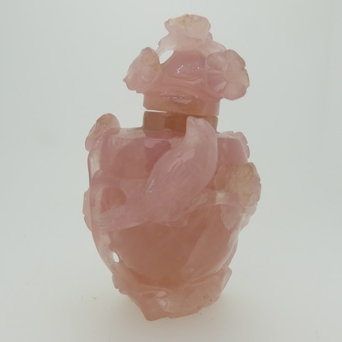 104 - A Chinese rose quartz Snuff Bottle, carved in reflief with flora and fauna, H 9cm, together with an ... 