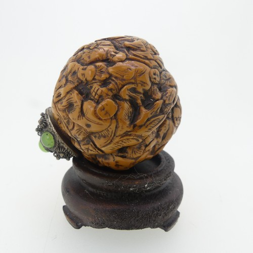 109 - A Chinese 'Luohan' carved walnut shell Snuff Bottle, depicting faces, with metal and stone stopper, ... 