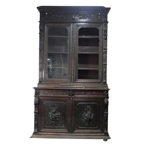 431 - A large Victorian carved oak Bookcase, the upper section enclosed by a pair of arched glazed doors (... 