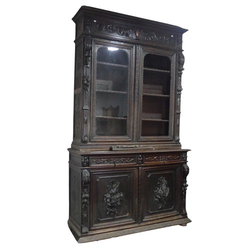 431 - A large Victorian carved oak Bookcase, the upper section enclosed by a pair of arched glazed doors (... 