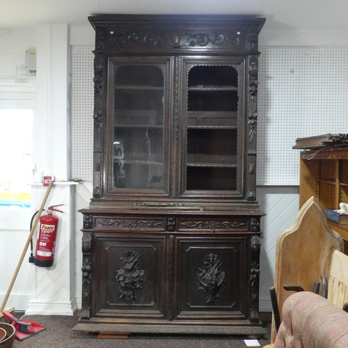 431 - A large Victorian carved oak Bookcase, the upper section enclosed by a pair of arched glazed doors (... 