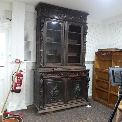 431 - A large Victorian carved oak Bookcase, the upper section enclosed by a pair of arched glazed doors (... 