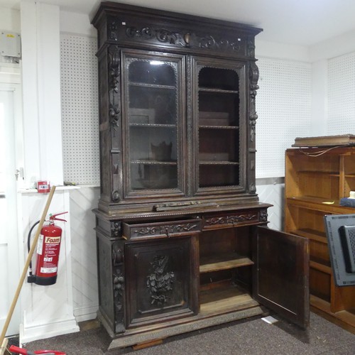 431 - A large Victorian carved oak Bookcase, the upper section enclosed by a pair of arched glazed doors (... 