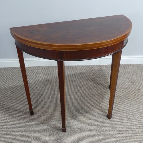 452 - An Edwardian mahogany demi-lune fold-over card Table, chequer inlaid top raised on tapering legs and... 